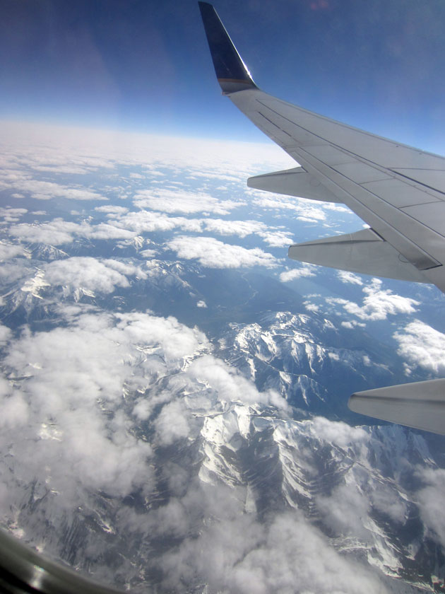 mountains and clouds as viewed through an airplane window