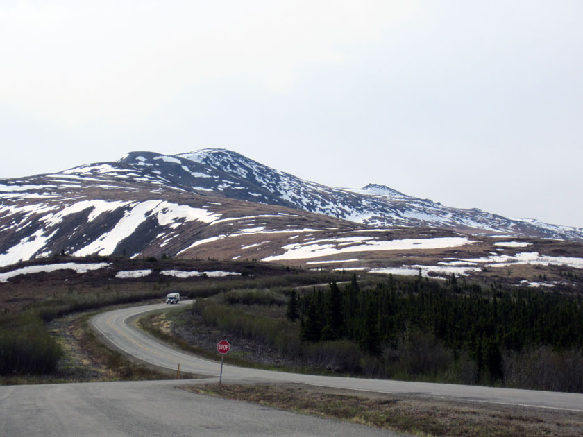 RV driving down a road in front of a mountain