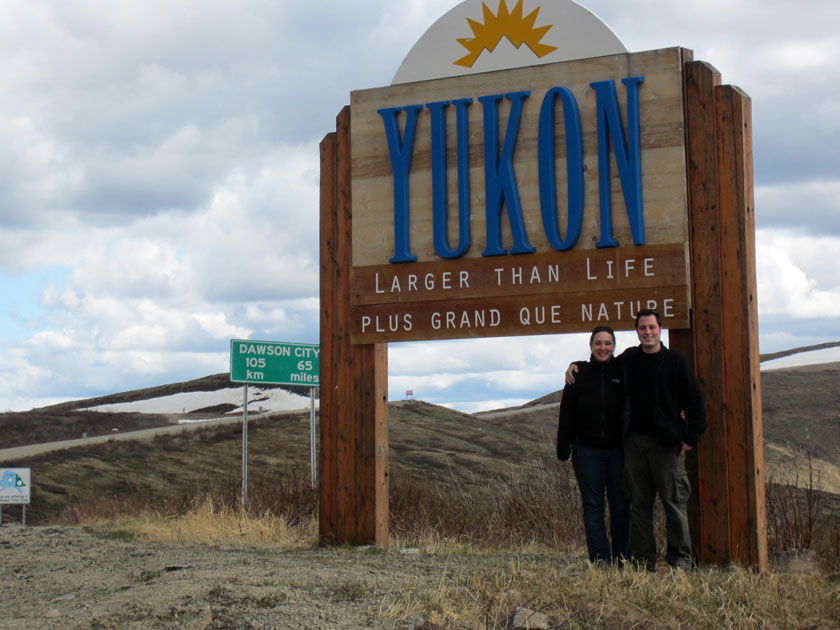 couple standing in front of a 'Yukon' sign