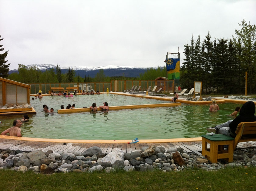 people swimming in a large hot springs pool