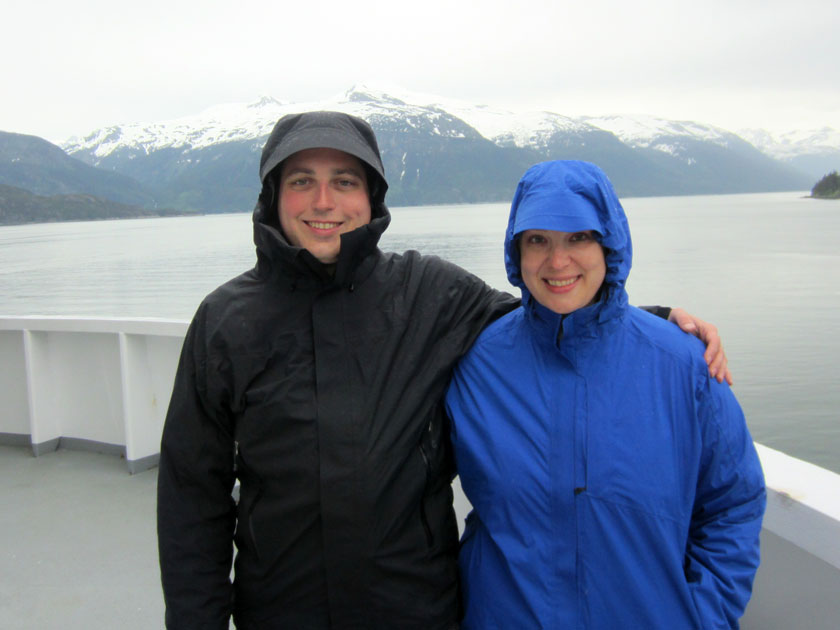 couple in rain jackets standing on a ferry