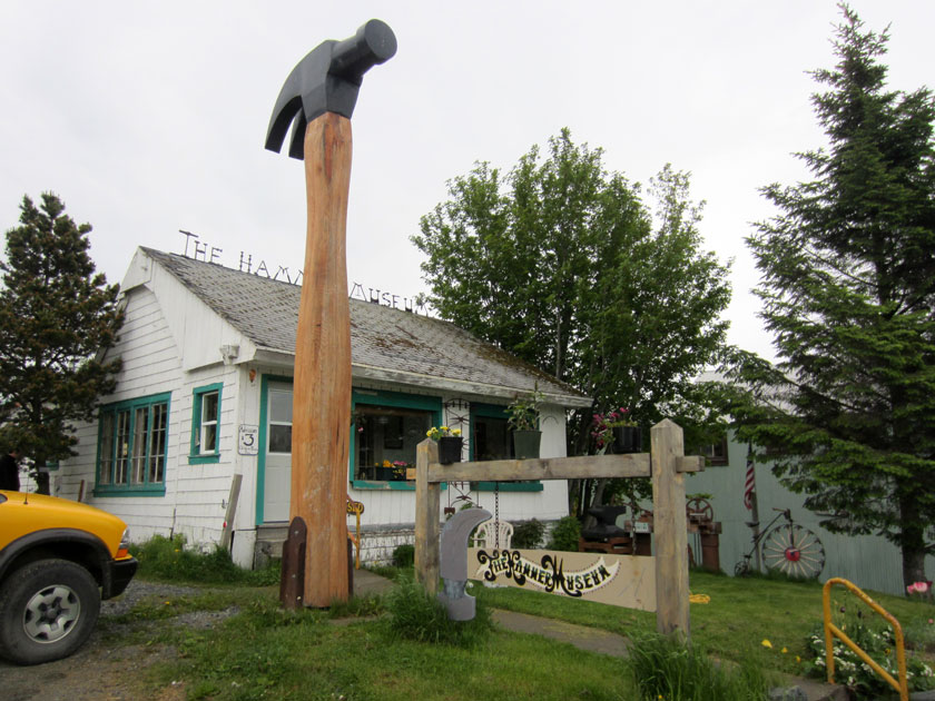 statue of a giant hammer in front of a small building with a sign reading 'The Hammer Museum'