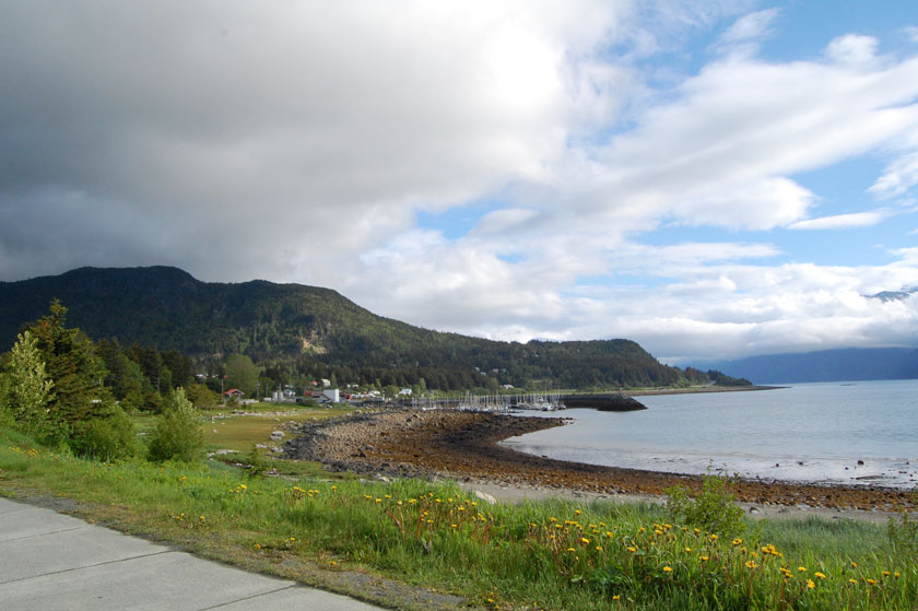beach along a cove with a harbor in the distance