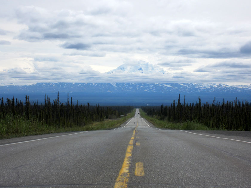 looking down a road toward a snow-covered mountain