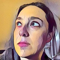Rachele DiTullio - headshot of a white woman with short brown hair looking up and to the side