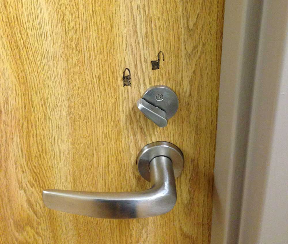Photo of a bathroom door lock where the lock is reversed so someone drew locked and unlocked icons on the door