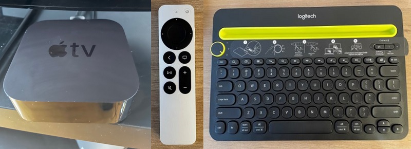 A small, square Apple TV console next to an Apple TV remote with a track pad and an Bluetooth keyboard.